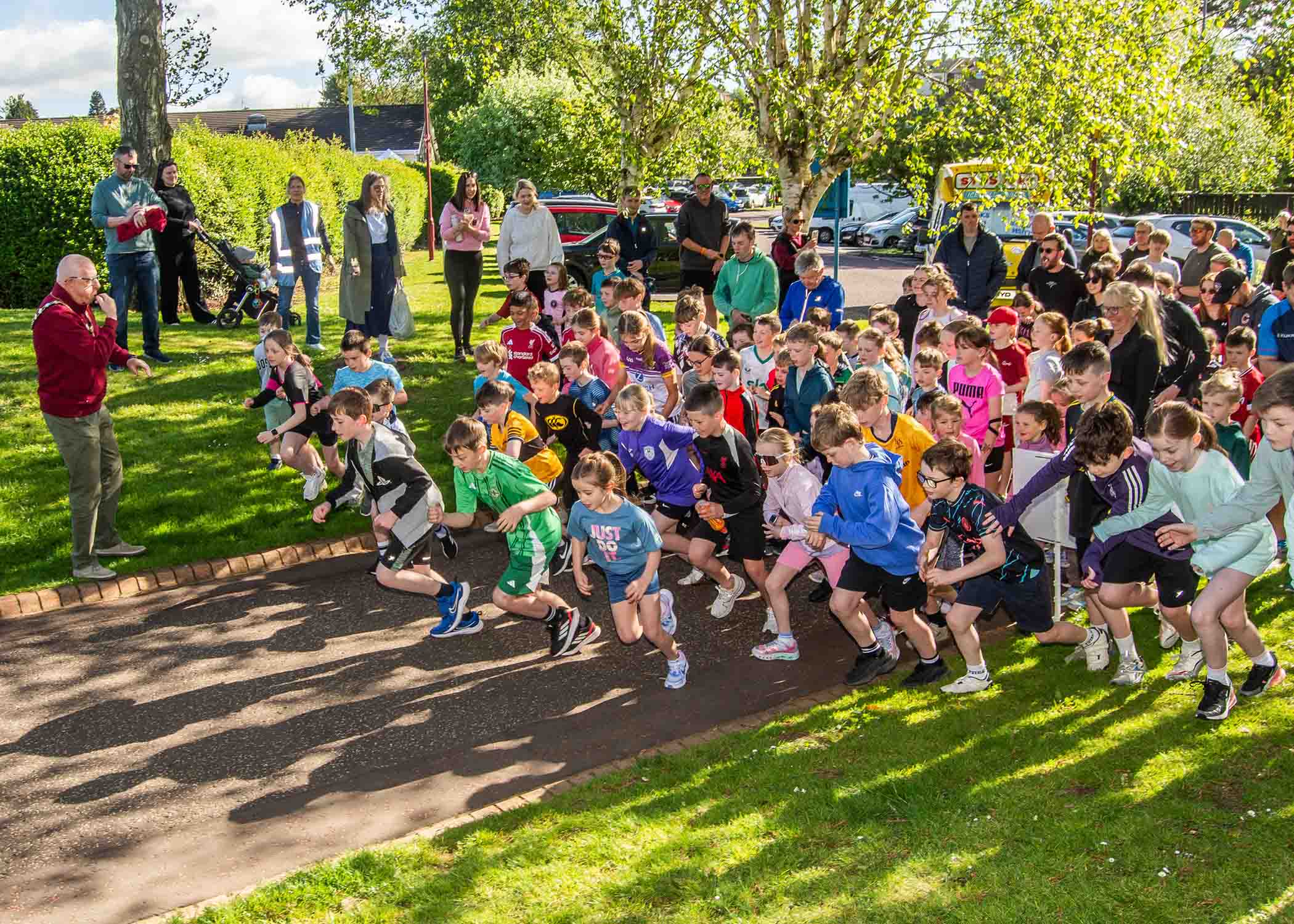 Mayor of Mid and East Antrim, Councillor Jackson Minford blows the starting whistle as young runners set off for the junior parkrun in The People's Park, Ballymena.