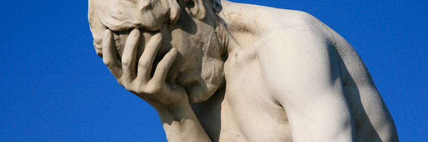 Photograph of a statue with his head in his hands