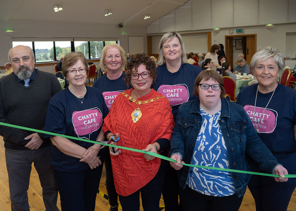 Friends and family of Glenravel GAA Club and Cllr Archie Rae join the Mayor to launch the new Chatty Café in Glenravel GAA Club.