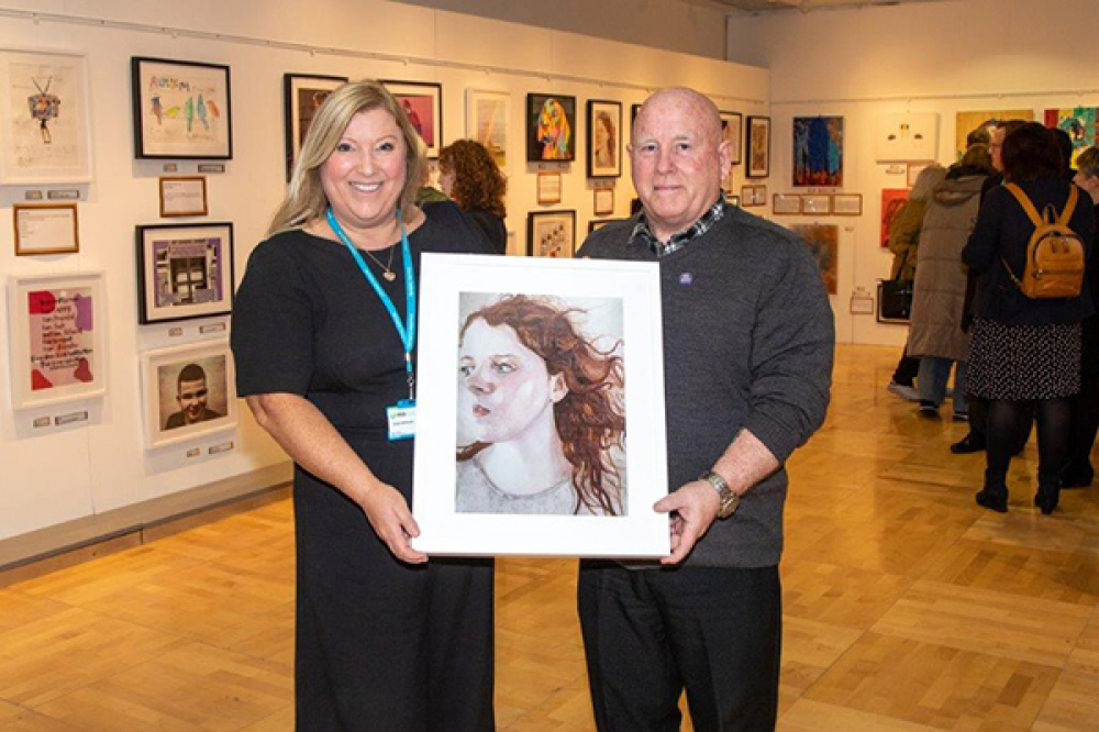 Cllr McKeown presented with an artwork by Gilliam Whiteside on behalf of the Education Authority Autism Support Service