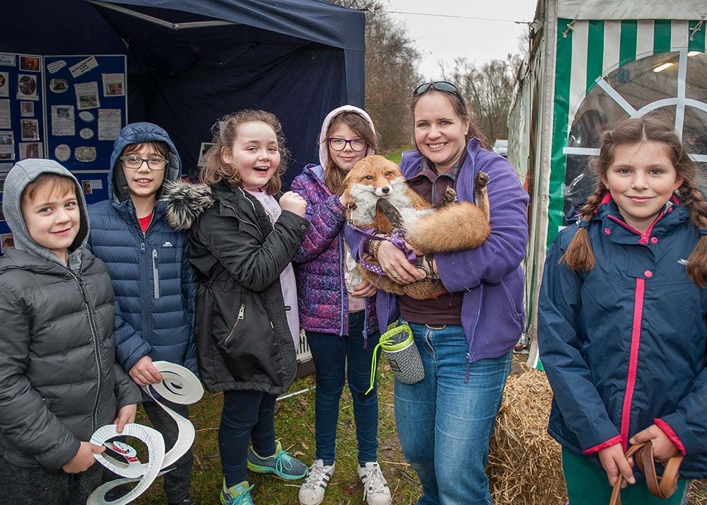 Linnie the Fox enjoying a cuddle from Debbie Dolittle, Josh and Owen Mairs, Freya Patton, Daisha Boyce and Amber Anand