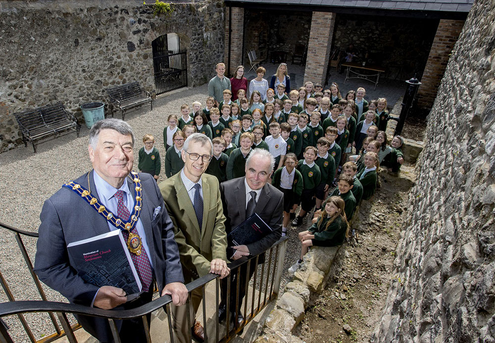 Mayor of Mid and East Antrim Alderman Noel Williams with Dr David Johnston, Chair of Gracehill Old School Trust, Manus Deery, Assistant Director, Department for Communities Historic Environment Division and pupils from Gracehill Primary School.