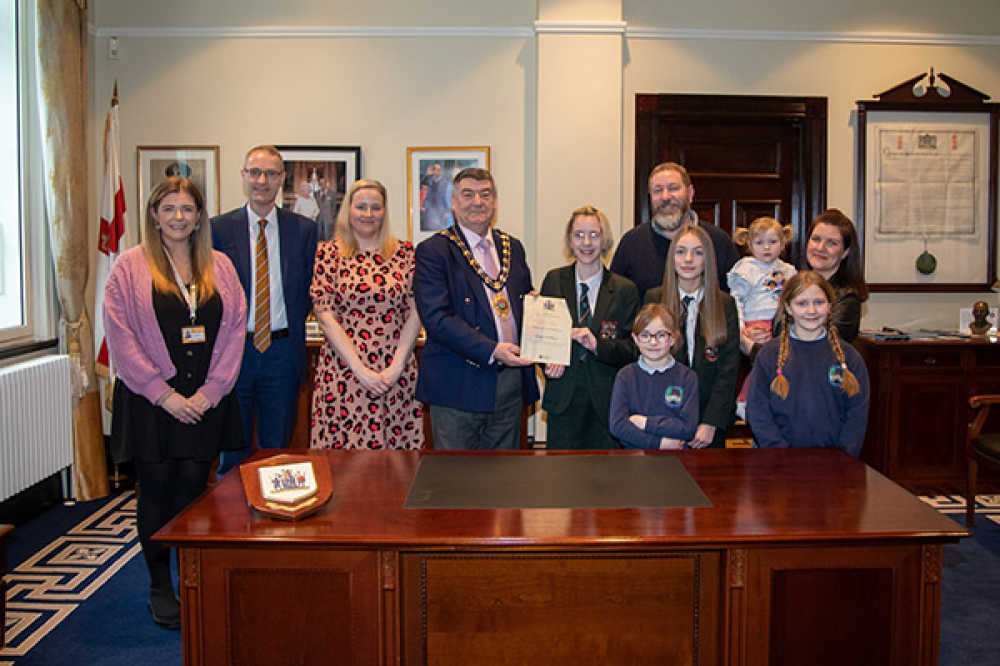 A photograph of Maggie McMillan, the Mayor, her family and others.