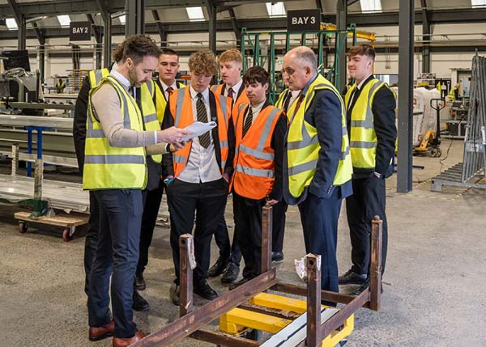 Mr. Heaney and pupils from Ballymena Academy being taken on a tour of the premises in Broughshane by Eugene Clarke.