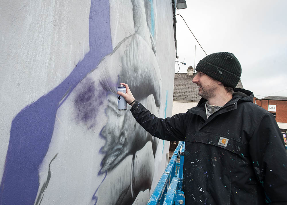 Mural artist working on a new piece of wall art