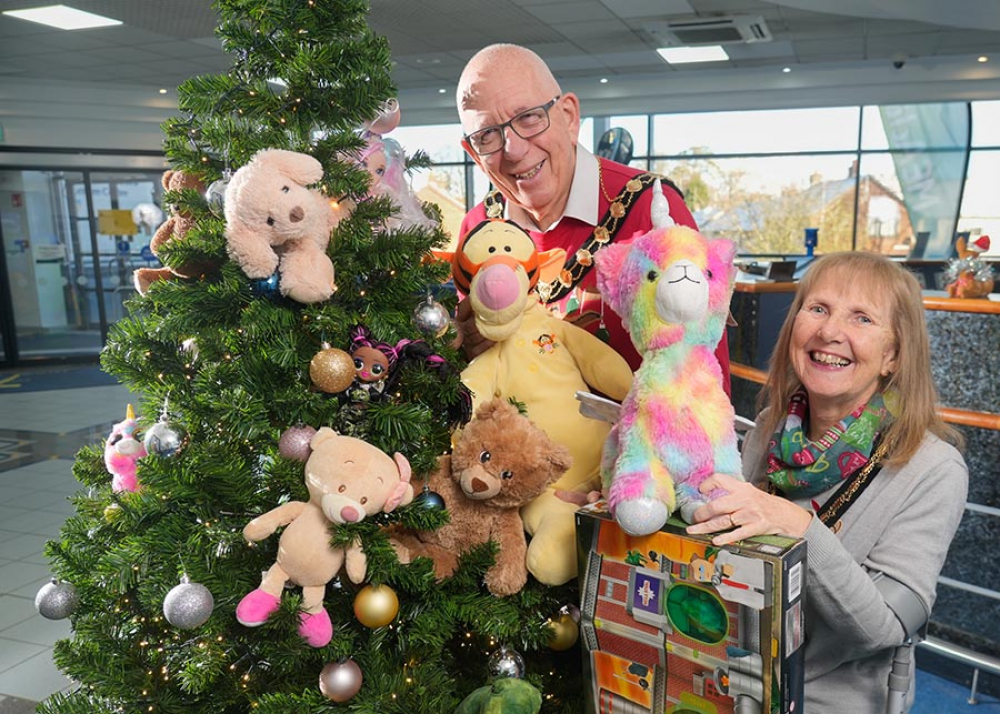 Mayor and Mayoress of Mid and East Antrim, Councillor Jackson Minford and Allison Minford, pictured with Christmas tree surrounded by toy donations by residents of Mid and East Antrim.