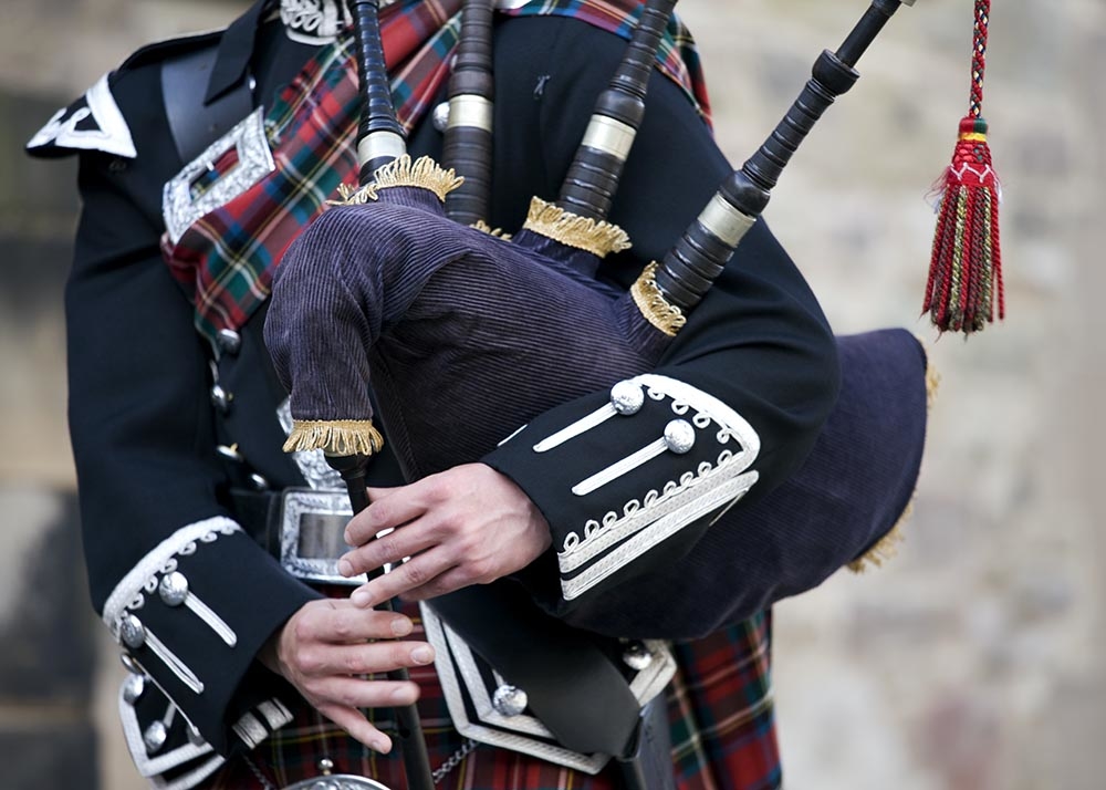 Close-up mid section of a man playing the Scottish bagpipes - Stock image